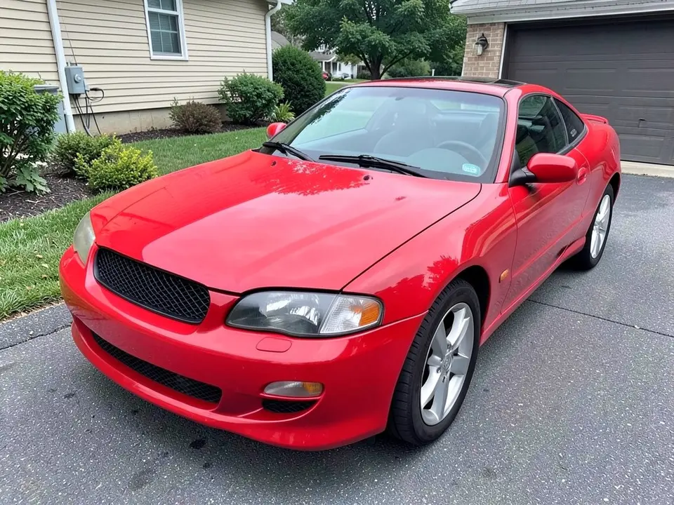 AI-drawn sample: a red two-door coupe seen from the front left corner, parked in a driveway beside a house with a garage